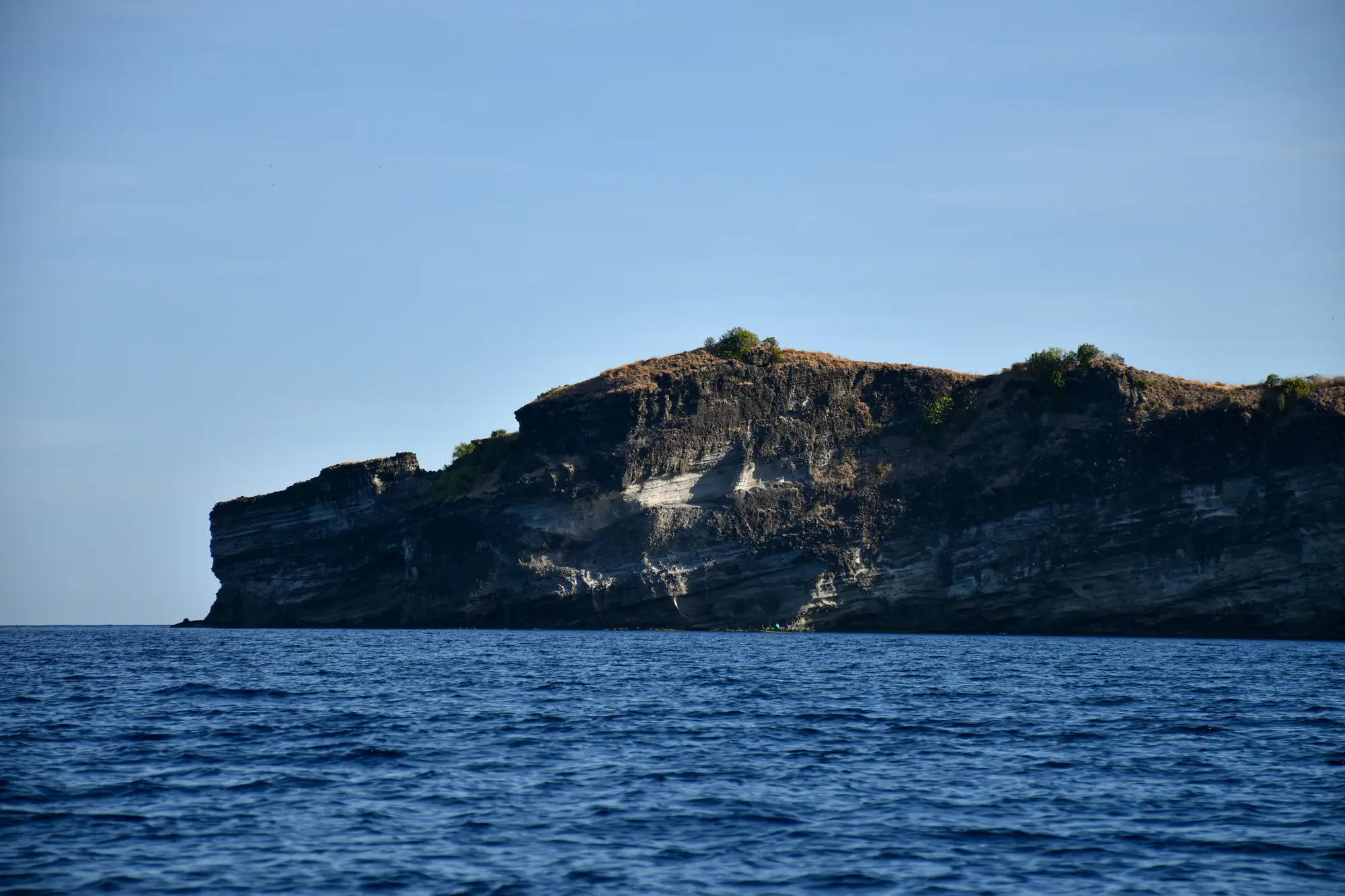 A Philippine island rising above open blue water.